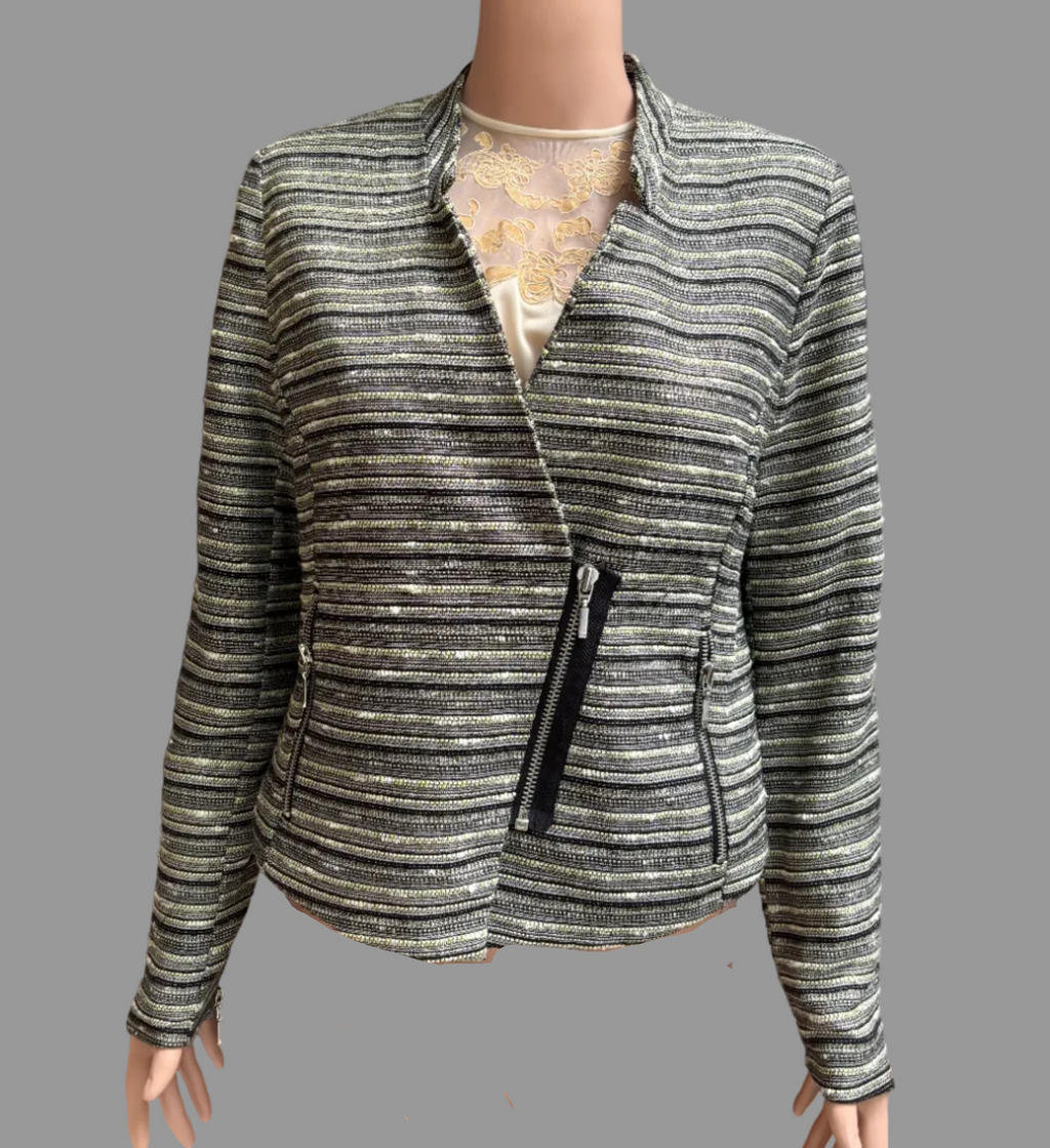 A women's zip-front jacket with horizontal metallic stripes in silver, gray, and black, displayed on a mannequin torso in front of brown curtains.