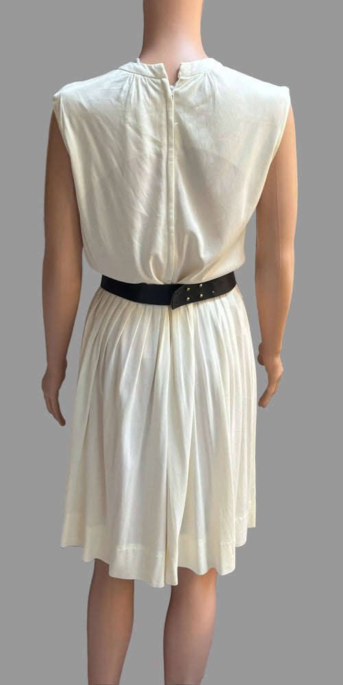 White dress on a mannequin against a brown curtain background