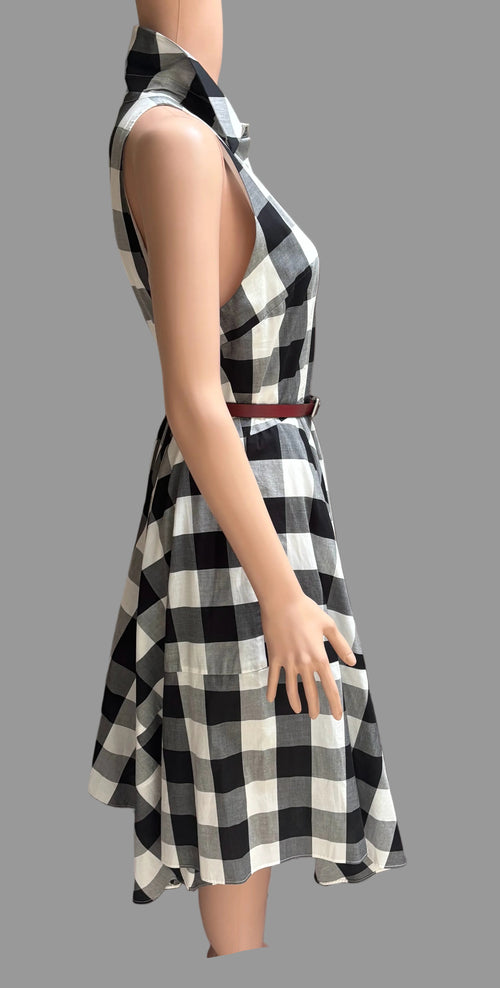 Black and white checkered dress on a mannequin against a brown curtain background