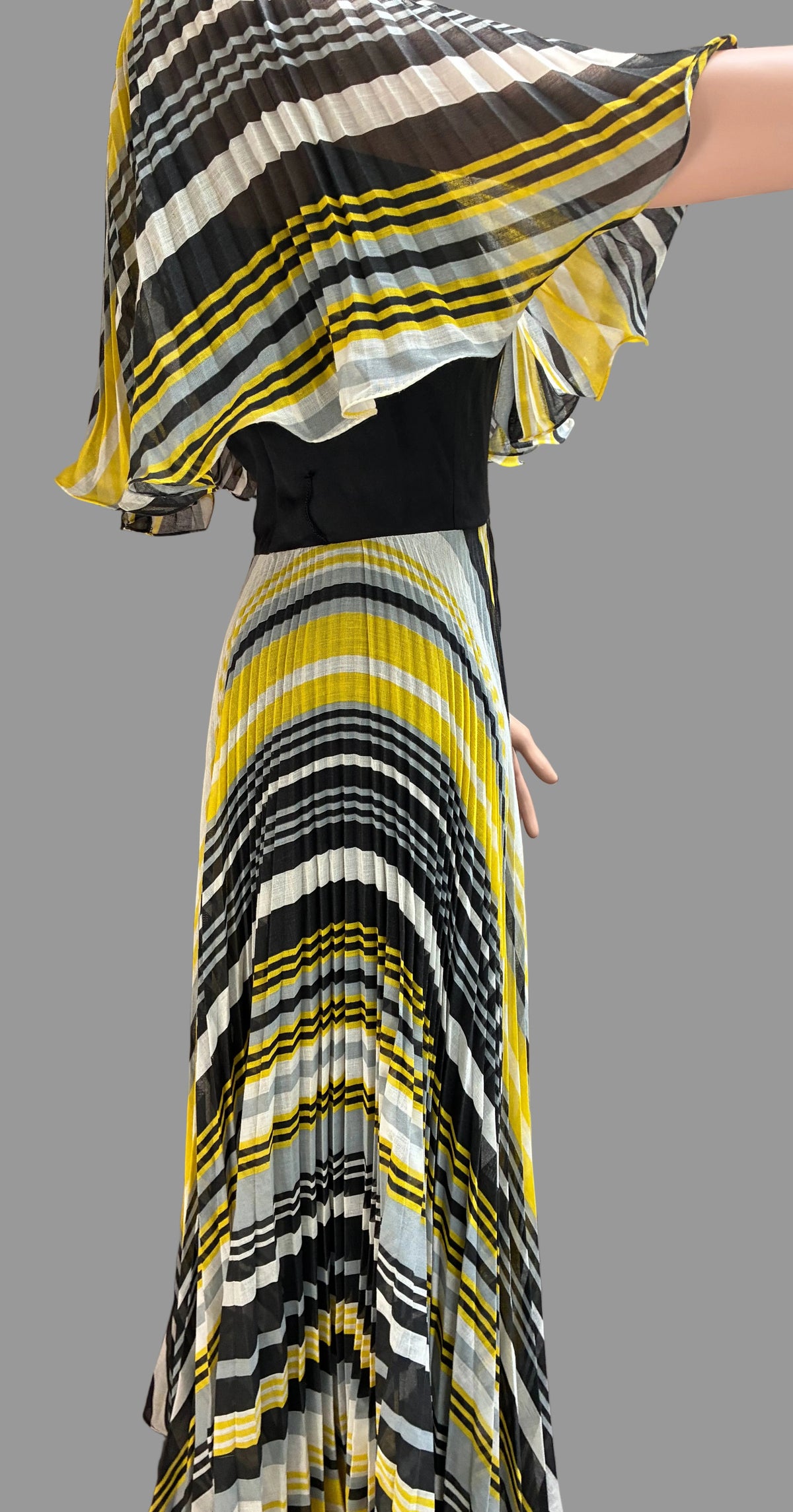 Woman wearing a colorful striped dress with a plain background