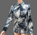 Mannequin wearing a patterned shirt with abstract design in a room setting.