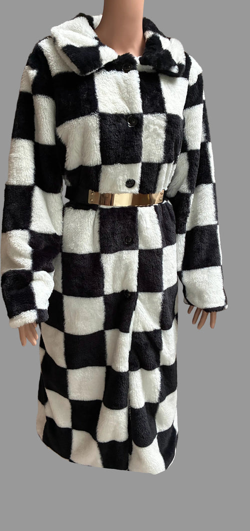 A black and white checkered faux fur coat with a gold belt, displayed on a mannequin against a brown curtain backdrop.
